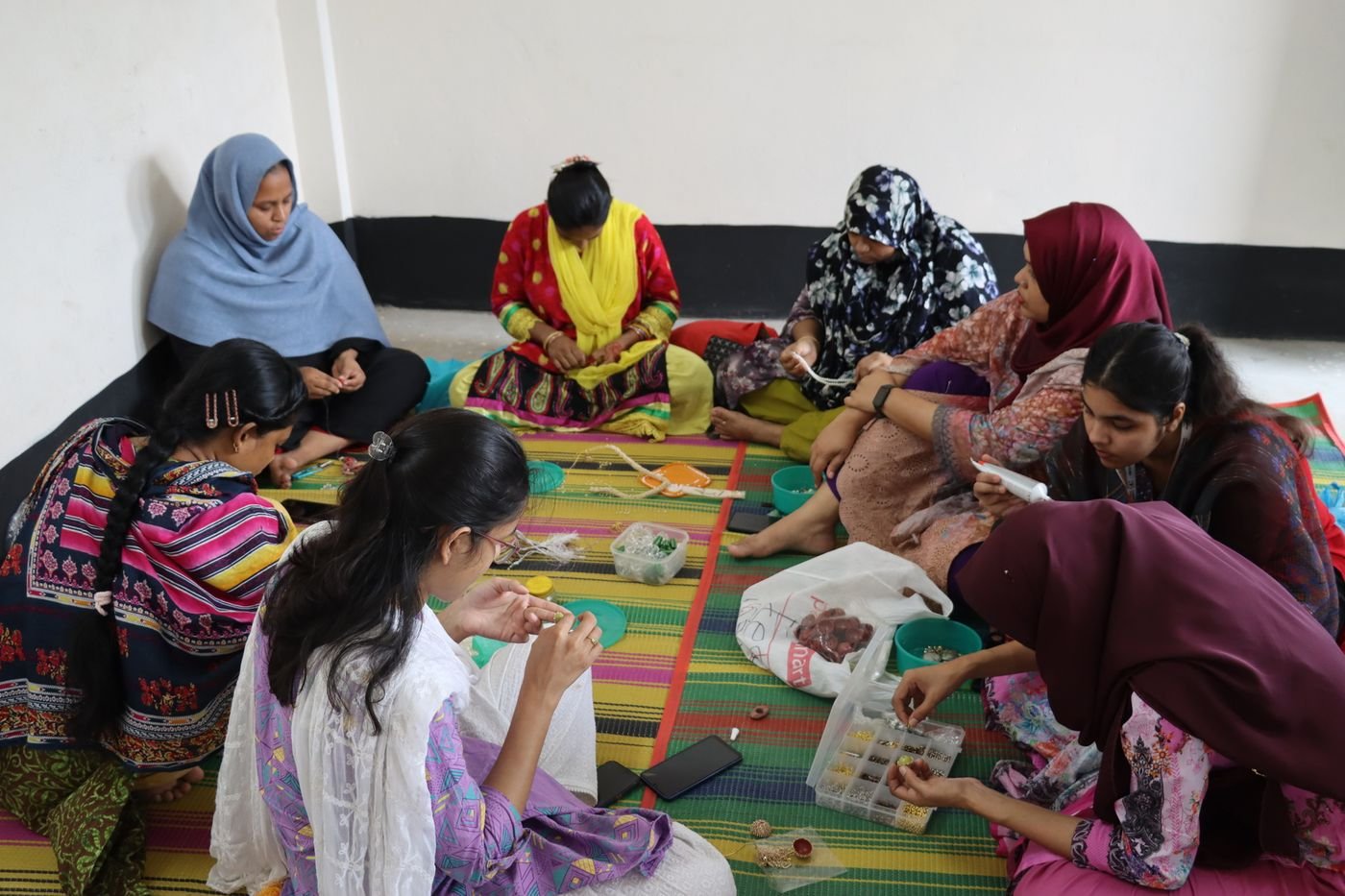Makers working together on beadwork at the hub